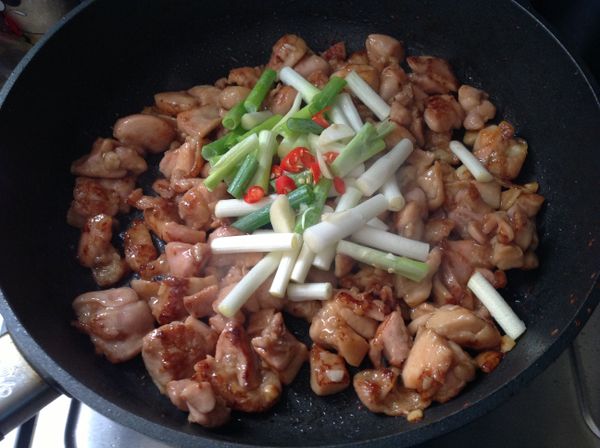 油脂出來後加入蔥段、辣椒丁拌炒