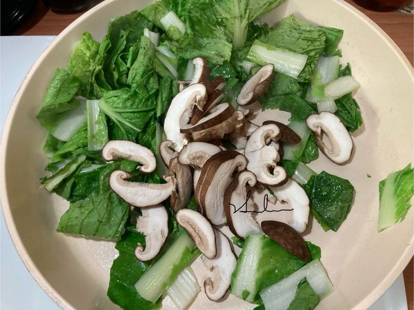 青菜略變色後再放入香菇拌炒。大火。