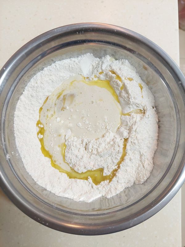 粉類調勻，挖洞並加入液體，慢慢混合