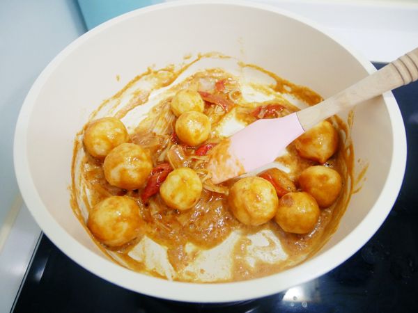 鍋中倒入金沙醬炒至冒泡後加入魚蛋、起士球及蟳味棒拌炒，盛盤灑上些許蔥花即可。