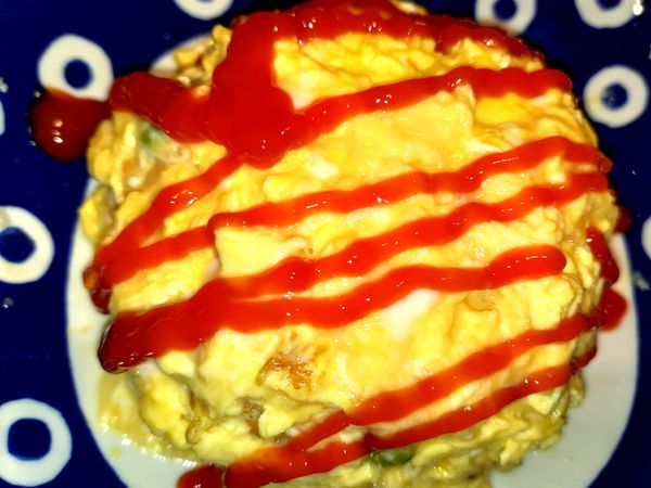 用湯匙撈出蛋，均勻舖在飯上，可以像抹奶油一樣輕輕抹開來塑型，完成後上面依喜好擠上番茄醬