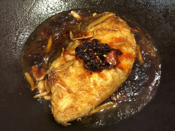 加入香麻醬並將醬汁澆淋於魚片上，均勻裹上醬色後再將魚片翻面煨煮。