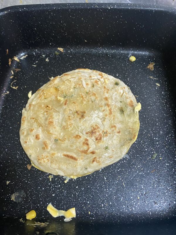 然後將玉米蛋糊倒入鍋中蓋上煎好的抓餅煎3-5分鐘，怕玉米太多不熟可以稍微壓一下表面直至可以輕鬆翻面為止