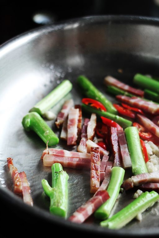 等到蒜頭上色之後，放入芥藍葉拌炒，然後下米酒。