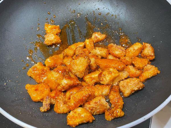 雞丁先煎熟，瀝乾油後，熱鍋倒入糖醋醬，糖溶解後就把雞丁最愛倒回去快速攪拌