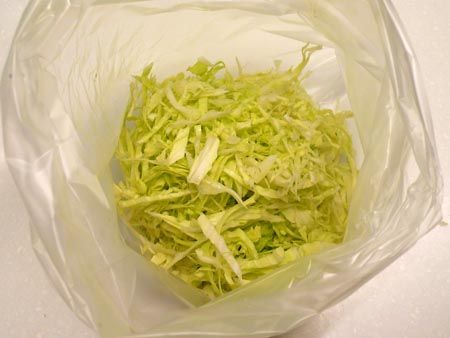 高麗菜葉切絲，放入乾淨塑膠袋，加糖醋鹽搖一搖