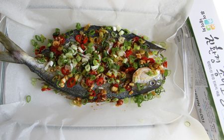 取一烤盤，鋪上韓國Pure-Nature萬用料理紙，放上薑片與蔥段放上鮮魚後均勻倒入泡椒拌醬，灑上少許蔥花，將烘焙紙捲起留一小口倒少許少許紹興酒增添香氣與水份，將料理紙捲起密合。包料理紙可以保護魚的水份，還可以讓成品不會過餘軟爛，烹調的速度也比蒸煮方式快了不少