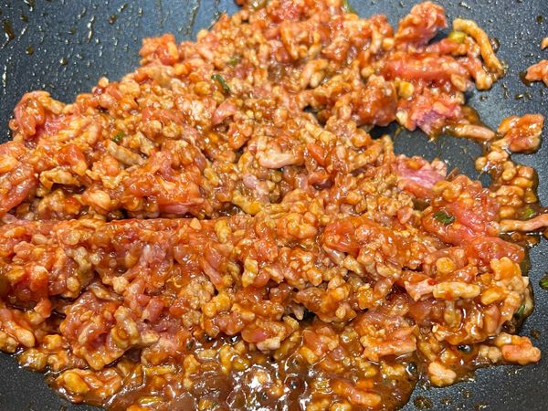 加入肉末、米酒拌炒至肉末8分熟