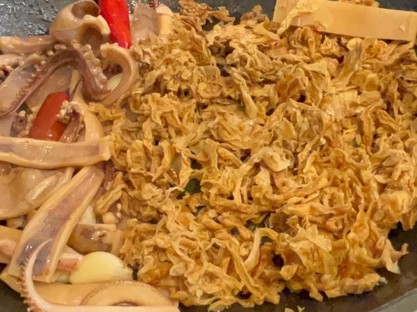 4、再放蒜、辣椒炒香，放魷魚、高麗菜乾炒香