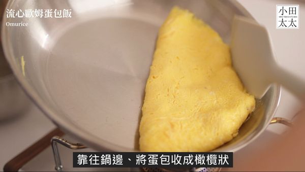 倒入蛋液利用鍋裡加熱， 先用筷子持續畫攪拌，一邊將四周凝結的蛋液與中央未凝結的蛋液拌勻，蛋液半凝固時用刮刀將蛋靠著鍋緣包覆成橄欖型，此時可以開小火讓接縫處凝固，接著再輕輕翻鍋，將蛋包均勻加熱，等表面定型後即可覆蓋在炒飯上，切開蛋包後灑上蔥花就完成了~