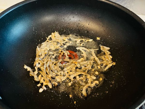 炒至小魚乾略呈金黃色，即可加入糯米椒拌炒