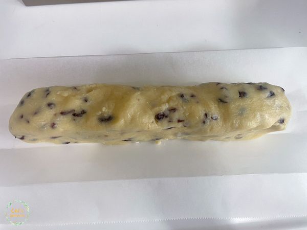 將餅乾麵團整形呈長條狀，連同烘焙紙放入Ｕ型模具中。