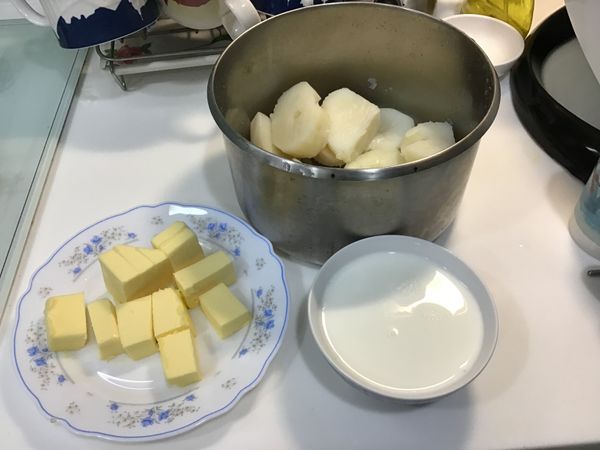 趁熱將煮鬆軟的馬鈴薯撈出, 並準備好奶油和牛奶.