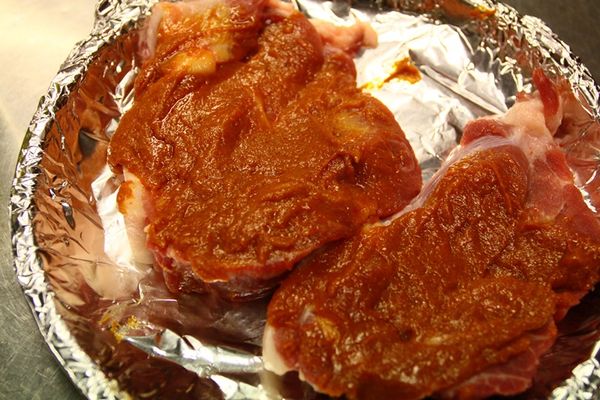 將梅花肉放到烤盤上，將醬汁抹上豬肉，蓋起來冷藏醃漬一夜。