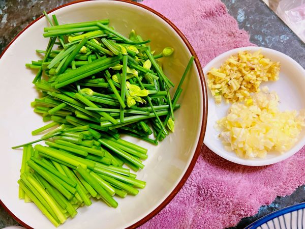 薑及蒜頭皆切末備用。
韭菜花洗淨後挑掉老的部份，切段，並將韭菜花的頭部跟尾部分開放。