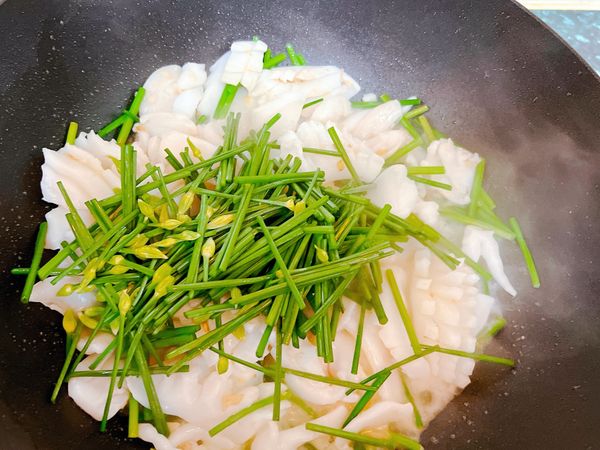 翻炒至韭菜花頭部稍微軟時，再將韭菜花尾部入鍋翻炒。