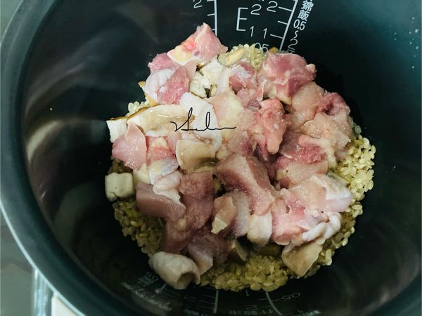 將洗好的糙米放入內鍋，舖上香菇和雞肉。
