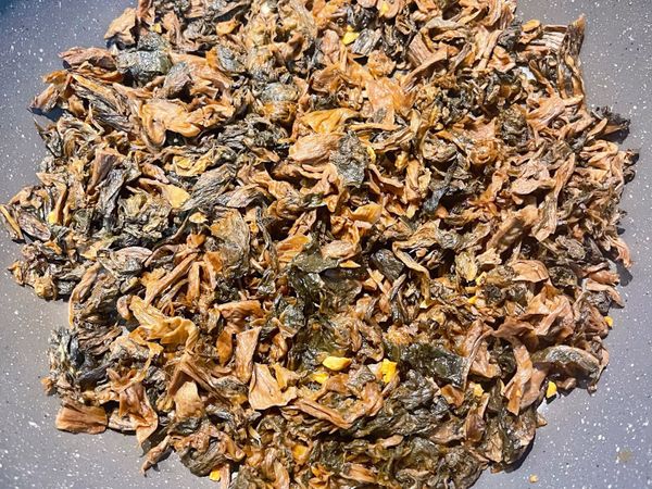 梅干菜入鍋與蒜頭拌炒；