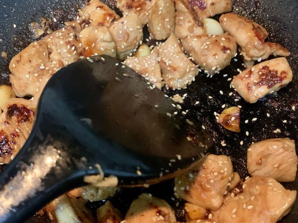 倒入白芝麻，開大火快速翻炒約1分鐘，記得要不停翻炒避免燒焦