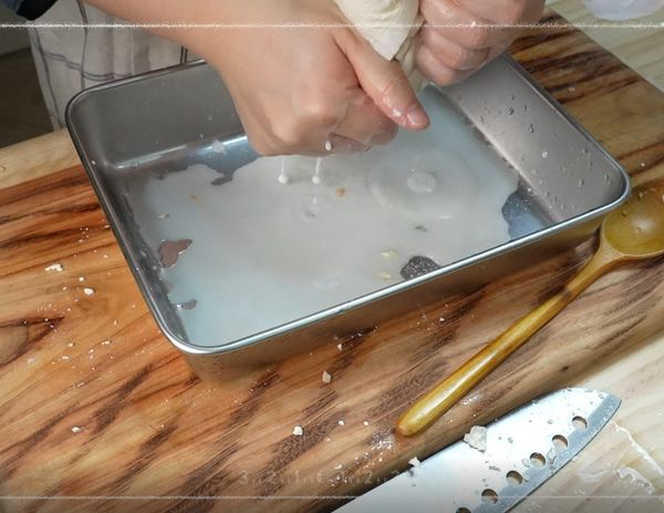 用廚房紙巾稍微吸去豆腐的水分~
將豆腐壓碎把豆腐放進網子裡擠出水分
