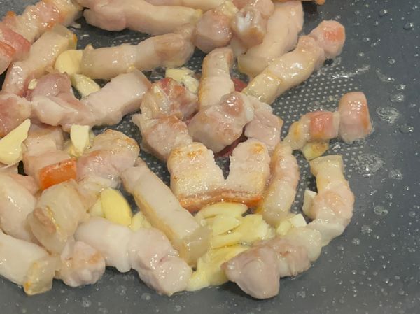 2、乾鍋放五花肉煸炒出油脂，再放蒜末炒香