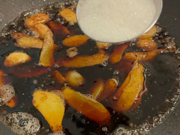 2、炒鍋放1匙沙拉油+1匙麻油，放薑片、蒜頭，小火煸至焦香