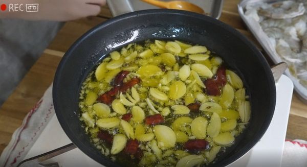 在平底鍋裡倒入充足的橄欖油
開小火放入蒜片 炸出帶蒜香的蒜油
要注意油溫不能太高
蒜末也一起下鍋炸一炸
炸到滿滿蒜香飄出時放入乾辣椒