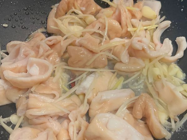 2、炒鍋少許油，炒香薑絲蒜末，再放肥腸翻炒後，放入酸菜