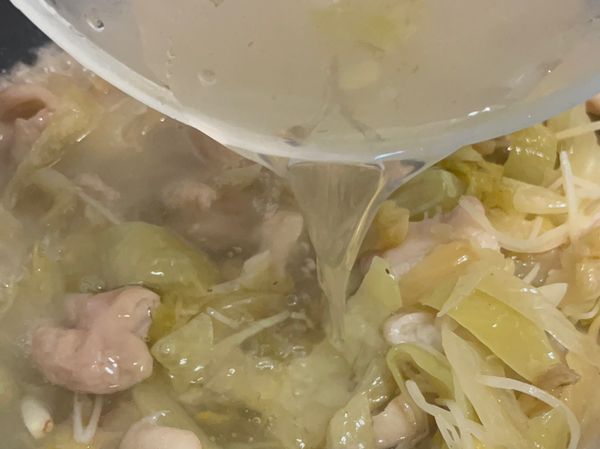 3、用糖、米酒、胡椒粉，和酸菜水煮沸後，蓋上鍋蓋，中小火悶煮10分鐘