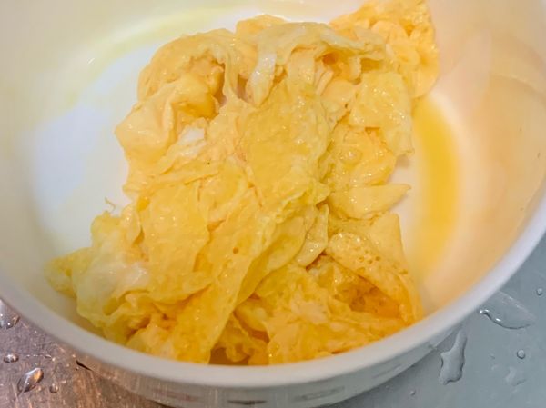 熱油，倒入拌勻的雞蛋液，待雞蛋周圍凝固後，”關火” 翻炒，以免過熟；翻炒後先將炒蛋盛起