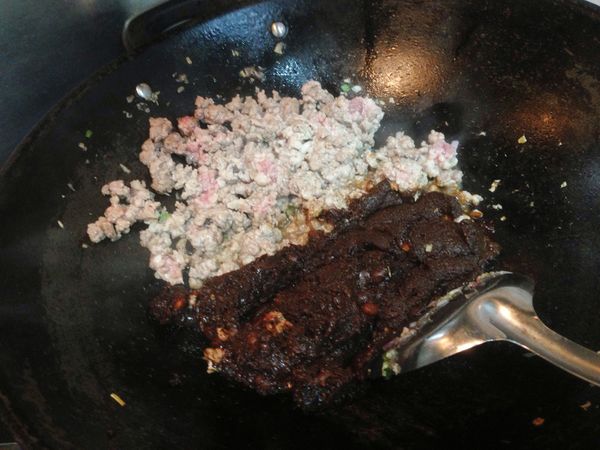 用剛剛煎豆干的剩油加點香油再度爆香些許紅蔥碎和薑末，開中火下豬絞肉翻炒，至肉面表皮有點發白的時候倒入豆瓣醬與甜麵醬一起拌炒