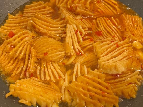 ❸加調味料翻炒均勻後，加水將蘭花干煨煮入味