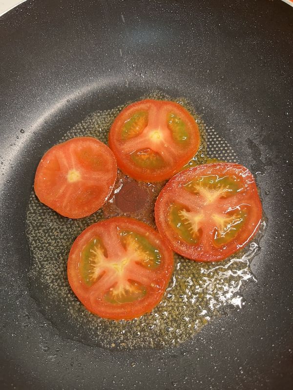 起油鍋，放入四片切片番茄