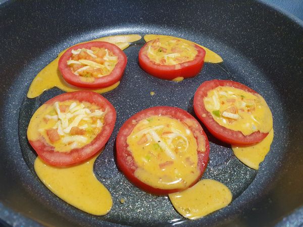 放上蕃茄片，再將麵糊填入，蓋鍋蓋煎熟