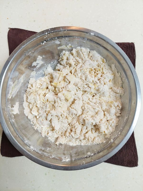 分次少量加入溫水，打成絮狀（用最低水量拌到無乾粉即可）