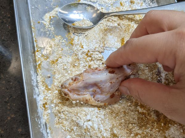 要準備動手之前先作兩個前置作業: 
1. 預熱烤箱210度  
2. 先在烤盤上鋪上烘焙紙後, 噴上耐高溫噴式酪梨油
然後把S&amp;B 特製咖哩粉1.5大匙+木薯粉100克在平盤上混合好, 就把醃好的雞翅兩面均勻的沾上粉, 然後放在烤盤上