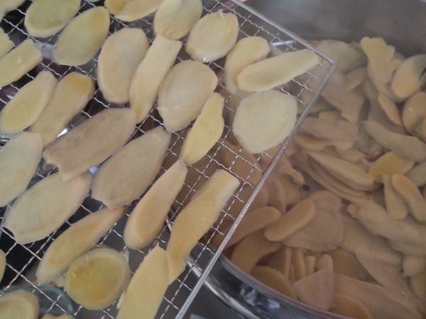 將薑片排列於烤盤上，送進果乾機以50度c溫度烘乾到酥脆無水份，大約5小時。