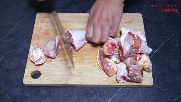 準備500g雞腿，將雞腿切塊。放入空碗，加入2g鹽，倒入清水，浸泡15分鐘，泡出血水後撈出洗凈備用。