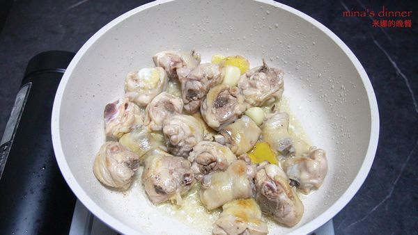 開中火，鍋中倒入少許油，不用等油熱，倒入姜、蒜頭、雞塊翻炒均勻。