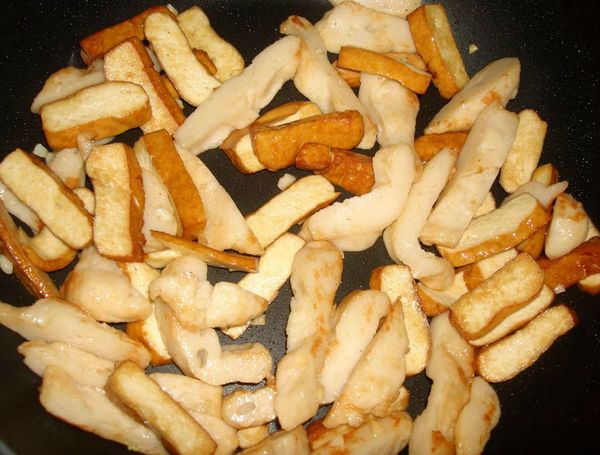 將豆干、甜不辣入鍋中以半煎半炒煸至金黃即可...