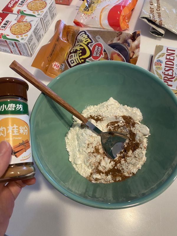 在碗倒入中筋麵粉、泡打粉、鹽、肉桂粉，並攪拌均勻。
