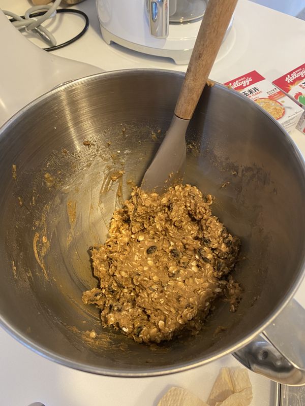 加入一開始混合好的中筋麵粉、泡打粉、鹽、肉桂粉，並拌入燕麥和葡萄乾。