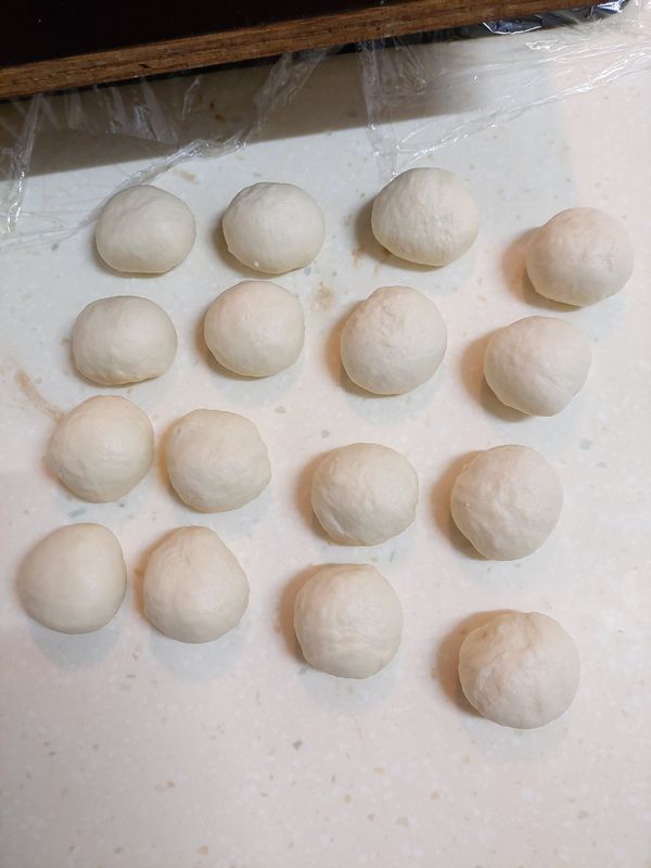 排氣並搓成條（光滑面須朝外），分切成16個(33g)麵劑並滾圓