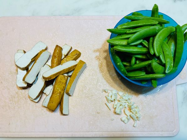 豆干切片，蒜頭切末，甜豆去頭截尾，並去除豆莢兩側的纖維絲