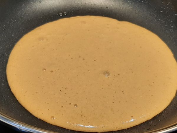 用廚房紙將鍋底抹上一層薄薄的油，小火加熱一兩分鐘，接著鋪放一些香菜，更有古早味，接著倒入一半麵糊。