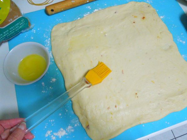 擀捲
將融化的奶油刷在麵糰上。