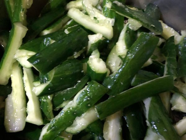 小黃瓜洗淨，去頭尾，先切段再拍碎，再切成一口大小，用半大匙的鹽去醃漬去澀水，時間是15分鐘。