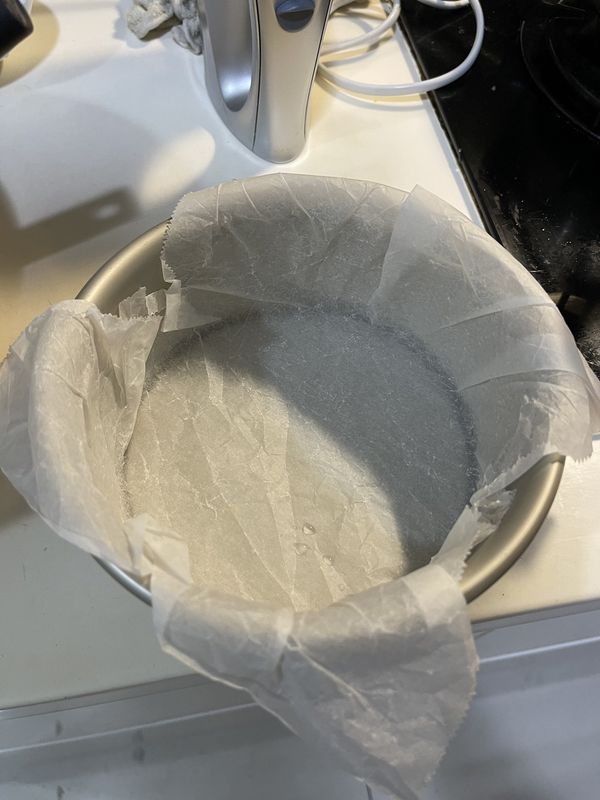 將烤箱預熱至攝氏200度，並在一個 6吋的蛋糕模具中放入烘焙紙，邊邊部分要確實壓緊壓實。