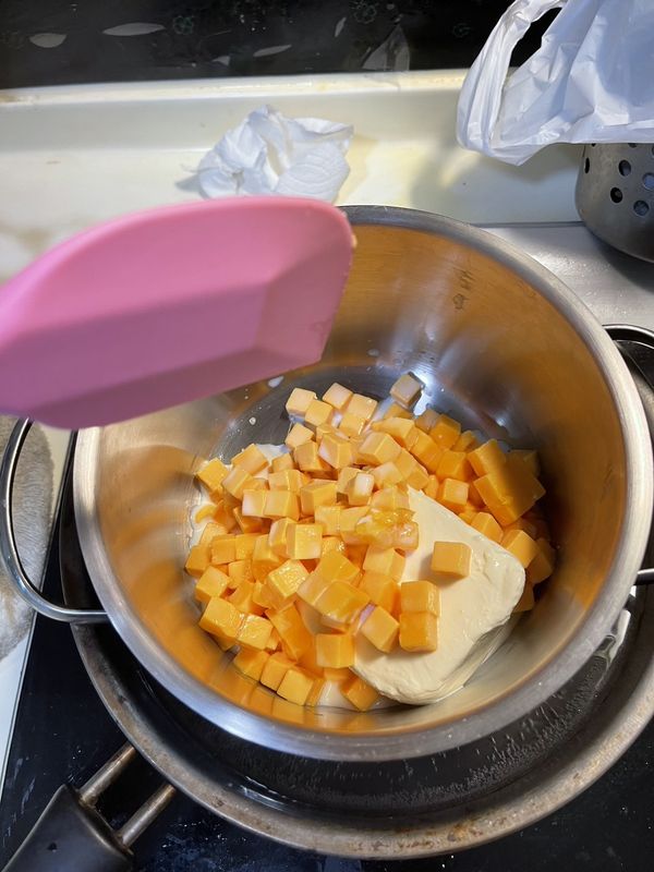 1.將紅色切達乳酪削成小塊，用耐熱碗加入牛奶，拿去微波1分鐘。
2.將奶油乳酪跟紅色切達乳酪混合，用隔水加熱，用電動攪拌機打均勻。