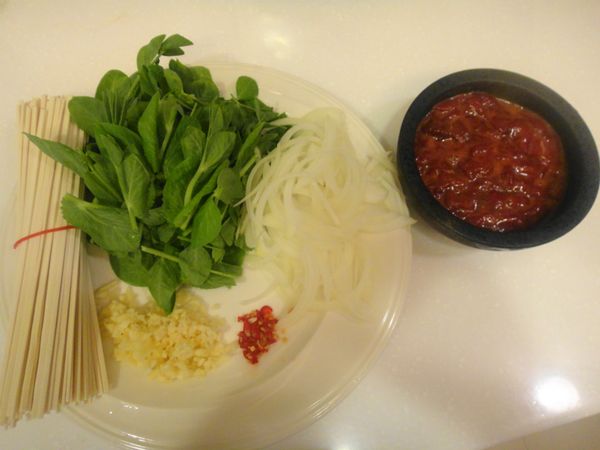 將[醃料]中除了太白粉之外的材料加入牛肉中拌勻備用,起鍋燒水準備煮麵條,洋蔥切絲,蒜頭辣椒切末備用